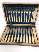 An Edwardian cutlery canteen with a set of twelve knives and forks, with bone handles (canteen: