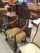 A Carolean style armchair with intricately pierced and carved back, with scroll arms above an