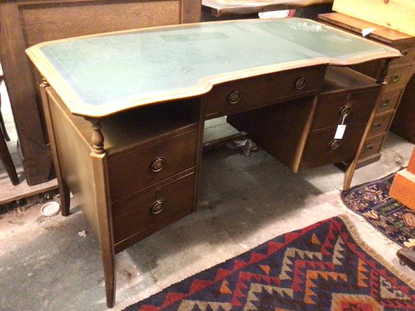 A 1930s/40s desk, the top with an inverted serpentine front, above a single frieze drawer, flanked