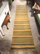 A flat weave runner of varied stripe design (300cm x 70cm)
