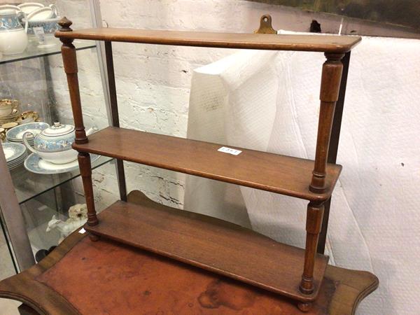 A late 19thc/early 20thc mahogany wall shelf with three tiers, on turned supports (57cm x 62cm x