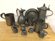 A quantity of pewter including two lidded ewers, a plate, two salts, a further measure (tallest: