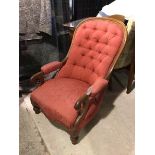 A Victorian library chair with arched back above an upholstered and button back, with padded arms