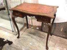 An 18thc style writing table, the serpentine top with leather writing surface, above two short