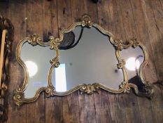 A modern rococo style wall mirror, with central cartouche shaped glass flanked by two other