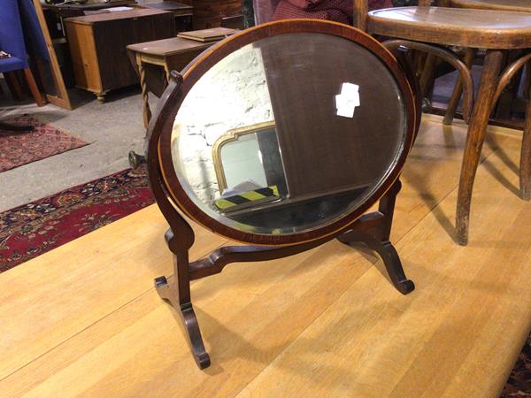 An Edwardian hinged dressing table mirror, the oval bevelled glass on trestle support (51cm x 53cm x