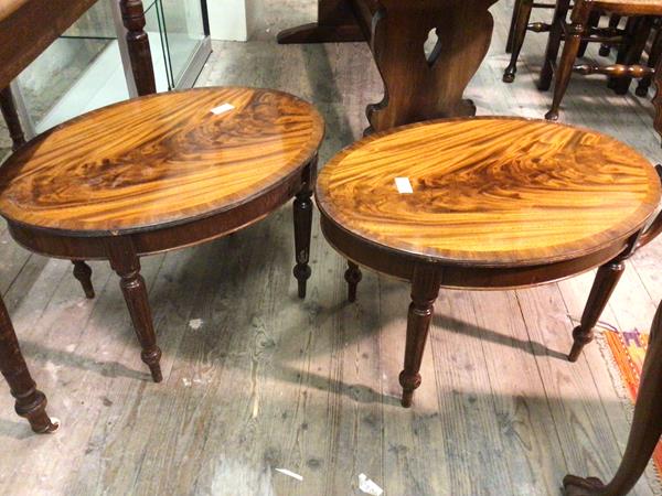 A pair of oval occasional tables with crossbanded tops, on turned tapering supports (42cm x 69cm x