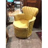 A modern boudoir chair, the fan back above curved arms and circular seat in a yellow snowflake