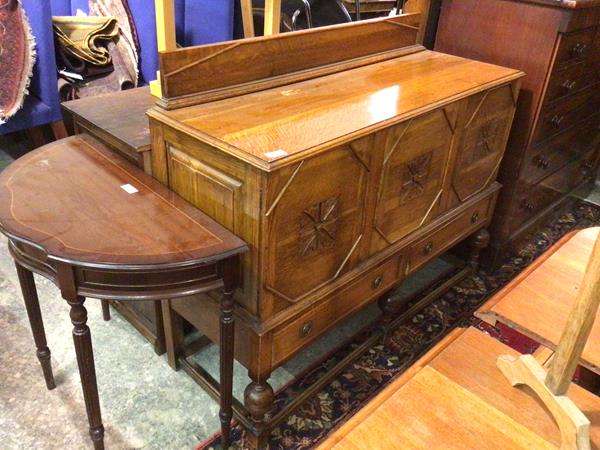 A 1930s/40s oak sideboard, with ledge back above a rectangular moulded top above three panel doors