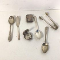 A mixed lot of silver including a sovereign case, three spoons, butter knife, match case and sugar
