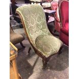 A Victorian walnut slipper chair, the scroll top with moulded sides, upholstered in a cut velvet