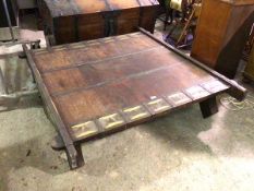 A Howdah style coffee table with wooden top flanked by sheet metal panels with matching sides and