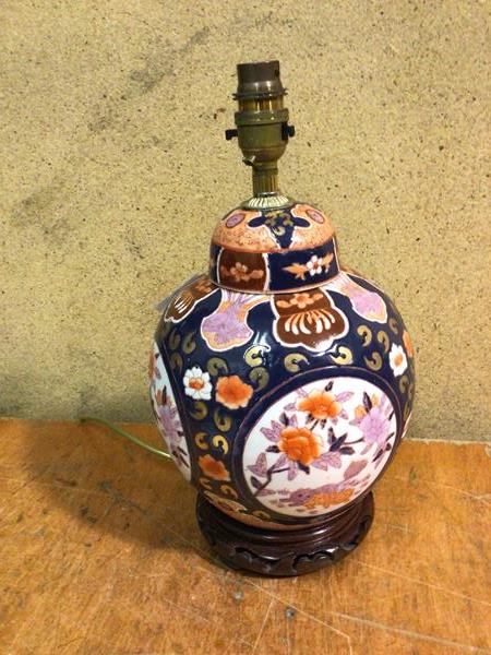 A modern Chinese style table lamp, possibly converted from ginger jar, on pierced wooden base (