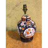 A modern Chinese style table lamp, possibly converted from ginger jar, on pierced wooden base (