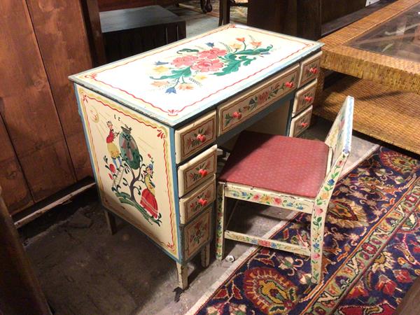 A 1950s/60s children's desk, with floral painted decoration to top and front, with figures to sides,