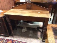 A 19thc oak side table, with pediment back with stylised heraldic panel above a rectangular top with
