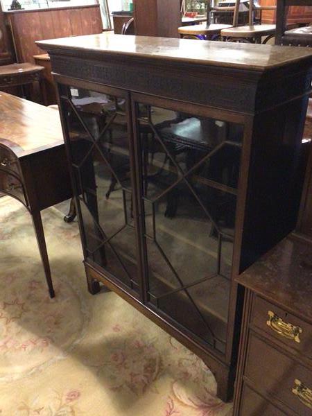 A Georgian style mahogany bookcase, the rectangular top above a blind fretwork frieze, with two