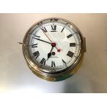 An early 20th century Smith's brass bulkhead clock, with eight-day movement, white enamel dial