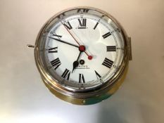 An early 20th century Smith's brass bulkhead clock, with eight-day movement, white enamel dial