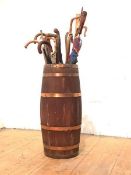 A late 19th century coopered barrel stick stand, with a group of sticks and umbrellas. Stand 67cm by
