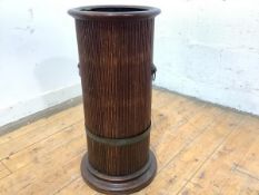 An Edwardian oak cylindrical stick stand, the flared top over a reeded body, applied with lion