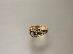 An 18ct gold single stone ring, the round-cut brown stone (possibly a cognac diamond) claw-set on