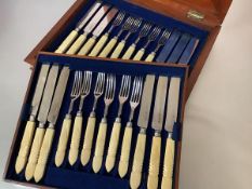 A set of twelve George IV ivory-handled silver fruit knives and forks, the silver blades and tines