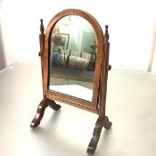 A small mahogany toilet mirror, the arched plate within a conforming string-inlaid frame, swivelling