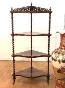 A Victorian rosewood four-tier corner whatnot, the fret-carved raised back over a serpentine