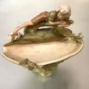A Royal Dux porcelain figural pedestal bowl, the oval bowl surmounted by a figure of a boy playing