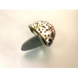 A white-metal mounted cowrie shell snuff, of characteristic form, the hinged cover naively