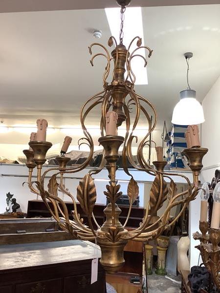 A large giltwood and toleware eight light chandelier, the baluster stem issuing scrolling leaf-