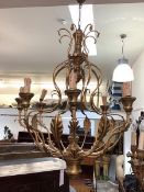 A large giltwood and toleware eight light chandelier, the baluster stem issuing scrolling leaf-