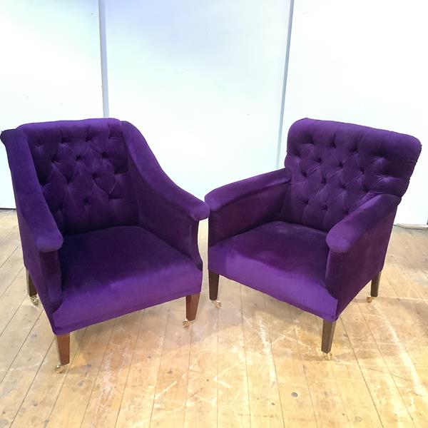 A near pair of easy chairs, each upholstered in a deep-buttoned purple velvet, raised on square