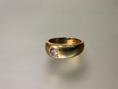 A gentleman's 18ct gold ring, the broad tapering band gypsy-set with a pale amethyst-coloured stone.