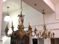 A matched pair of handsome patinated metal chandeliers, one of twelve lights, the other fifteen,