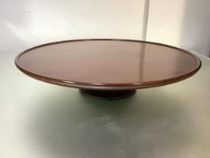 An Edwardian mahogany Lazy Susan, the revolving circular tray top on a turned stem and domed