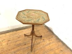 A George III oak tripod table (alterations), the shaped octagonal top inset with a petit point panel