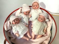 The Dionne Quintuplets: a partial set of four Armand Marseille bisque head baby dolls, each in