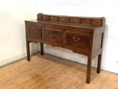 A late 18th century oak dresser base, the rectangular top with a superstructure (possibly