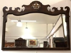 A walnut fretwork small overmantel mirror in 18th century style, the shaped rectangular plate within
