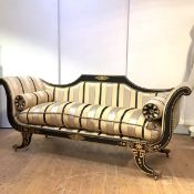 A large gilt-decorated and ebonised sofa of Regency design, with outscrolled arms and shaped sabre