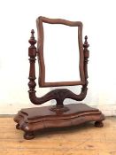 A Victorian mahogany toilet mirror, the undulating swing frame on turned uprights centred by a