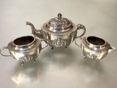 An Indian white metal three piece tea service, c. 1900, each piece of oval form, the teapot with