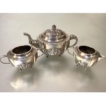 An Indian white metal three piece tea service, c. 1900, each piece of oval form, the teapot with