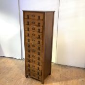 An Edwardian tall oak filing cabinet, of twelve drawers each fitted with a cast-metal drop handle,