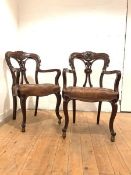 A pair of William IV mahogany library open armchairs, the shaped crest rail centred by a carved