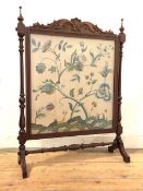 An Edwardian mahogany firescreen, the frame surmounted by a scroll-carved pediment and two turned