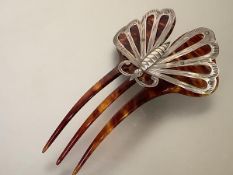 An Edwardian silver-mounted tortoiseshell lady's hair ornament, the three-prong comb surmounted by a