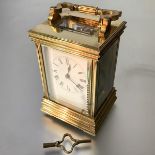 A French brass-cased carriage clock, c. 1900, the case with stepped base and shaped part-reeded
